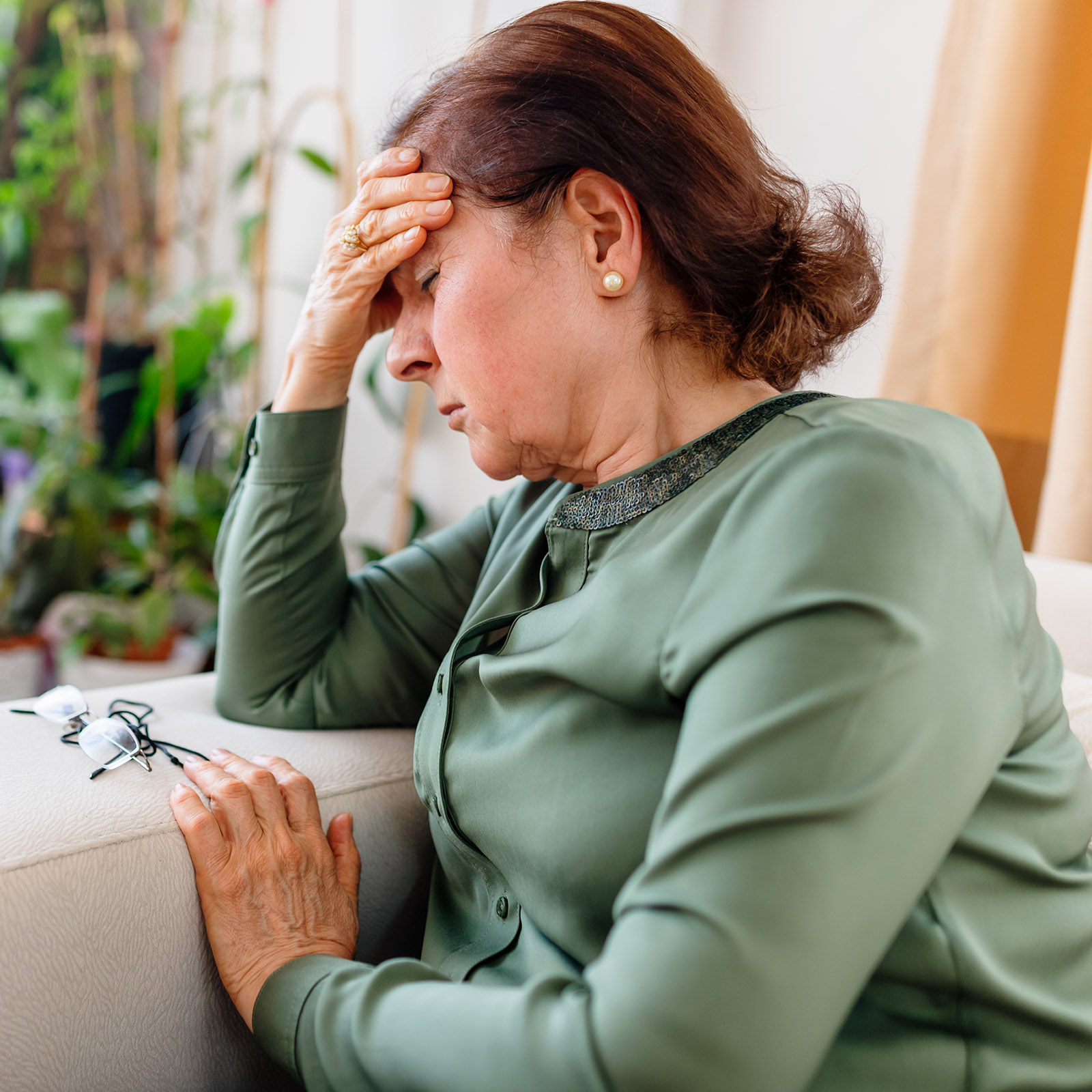 A Distraught Senior WoMan Suffering From a Migraine