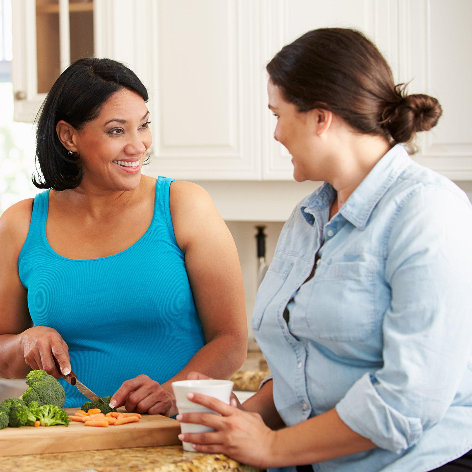 Two Overweight Women On Diet Preparing Vegetables in Kitchen